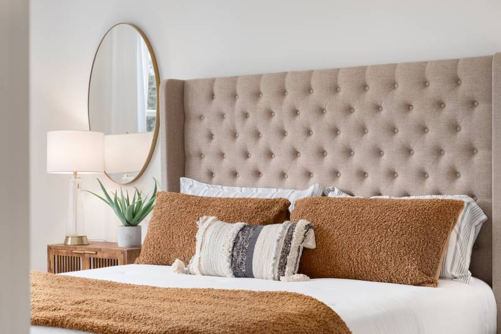 Dormitorio en tonos tierra con cabecero de cama de capitoné. Dormitorio en tonos tierra con cabecero de cama de capitoné.