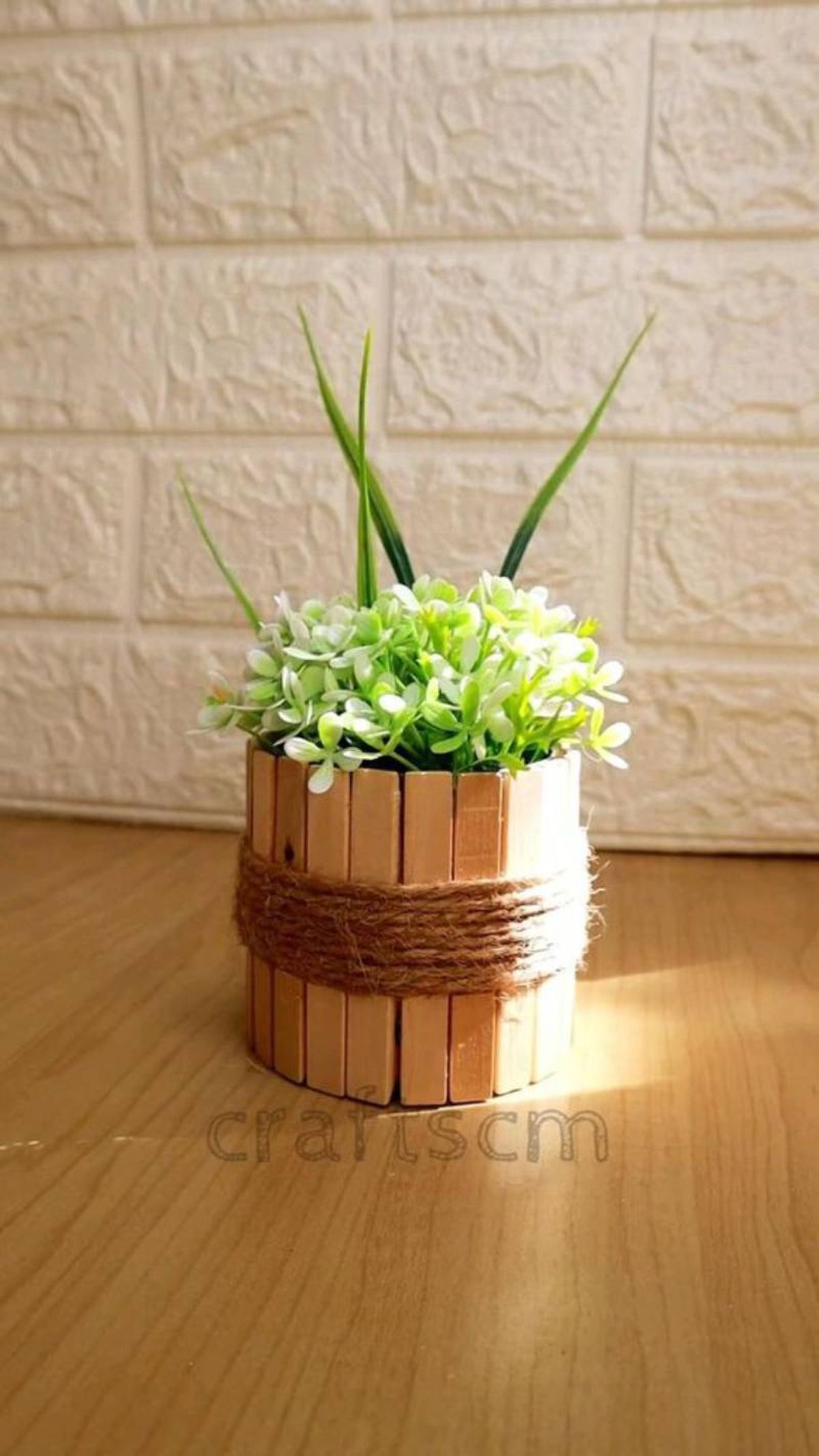 Maceta decorada con palos y cuerda.