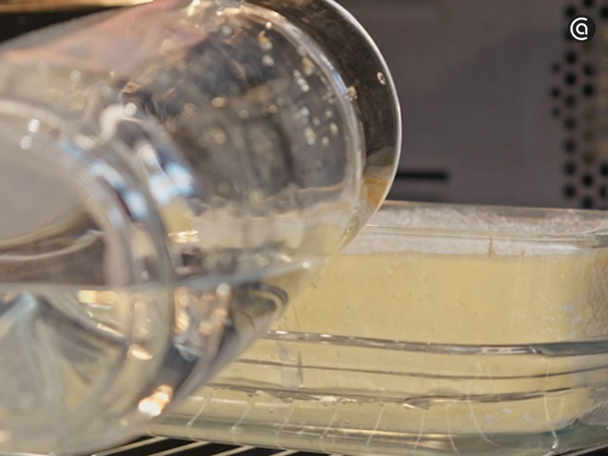 El molde se acomoda en la bandeja con agua para garantizar una cocción suave al baño maría.