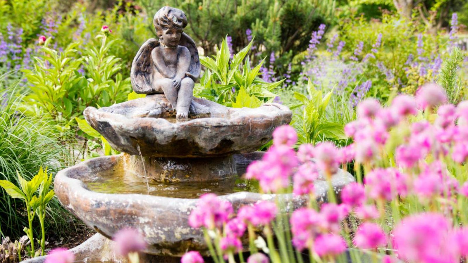 Estatua de un ángel en una fuente de jardín Estatua de un ángel en una fuente de jardín