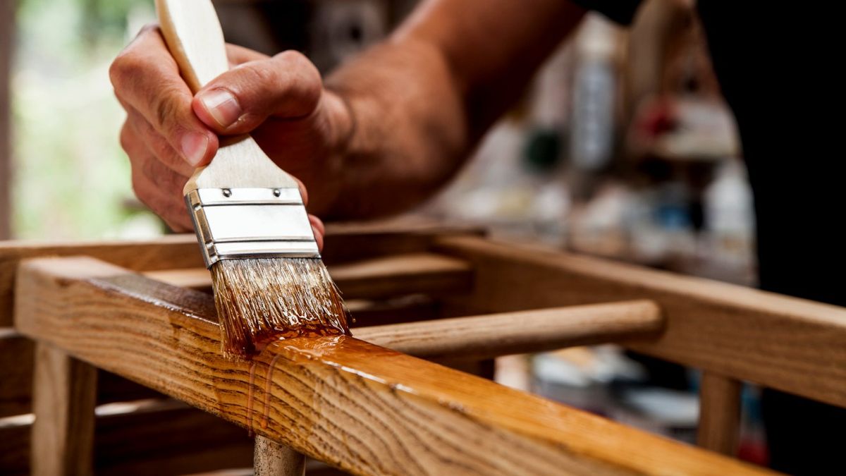 Persona barniza una pieza de madera