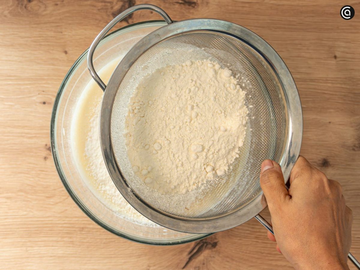 Añade la harina tamizada a la mezcla y remueve hasta integrar