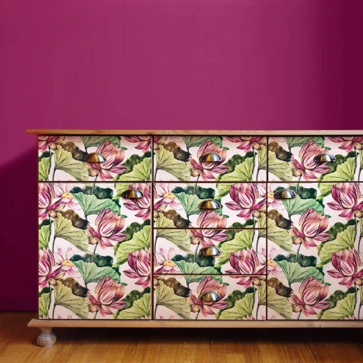 Mueble forrado con vinilo con estampado de hojas verdes y flores rosas.