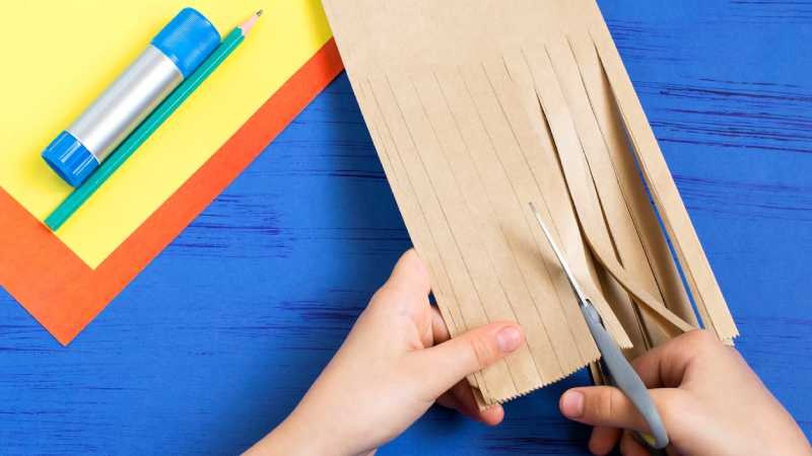 Primer paso para hacer el árbol de cartón, cortar una parte de la bolsa en tiras.