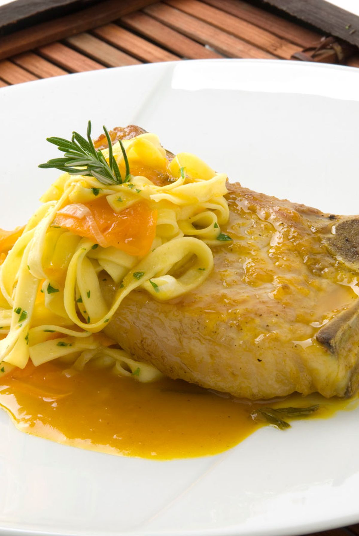 Chuleta de cerdo con salsa de naranja y pasta