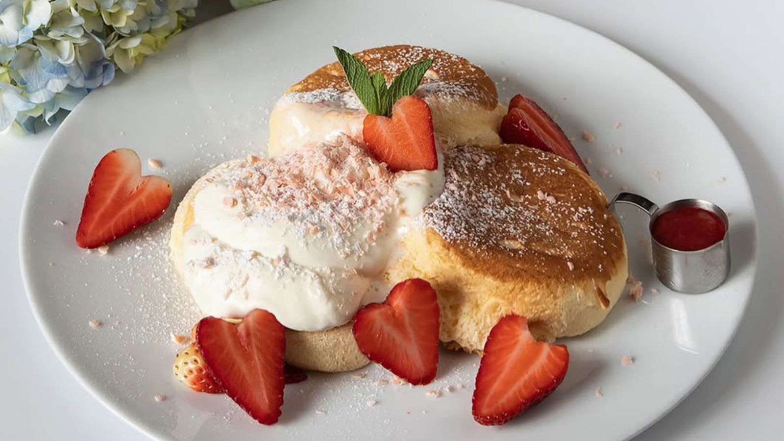 Soufflé pancakes de Panda Patisserie, con nata y fresas: un ejemplo de la textura ligera que define este dulce japonés.