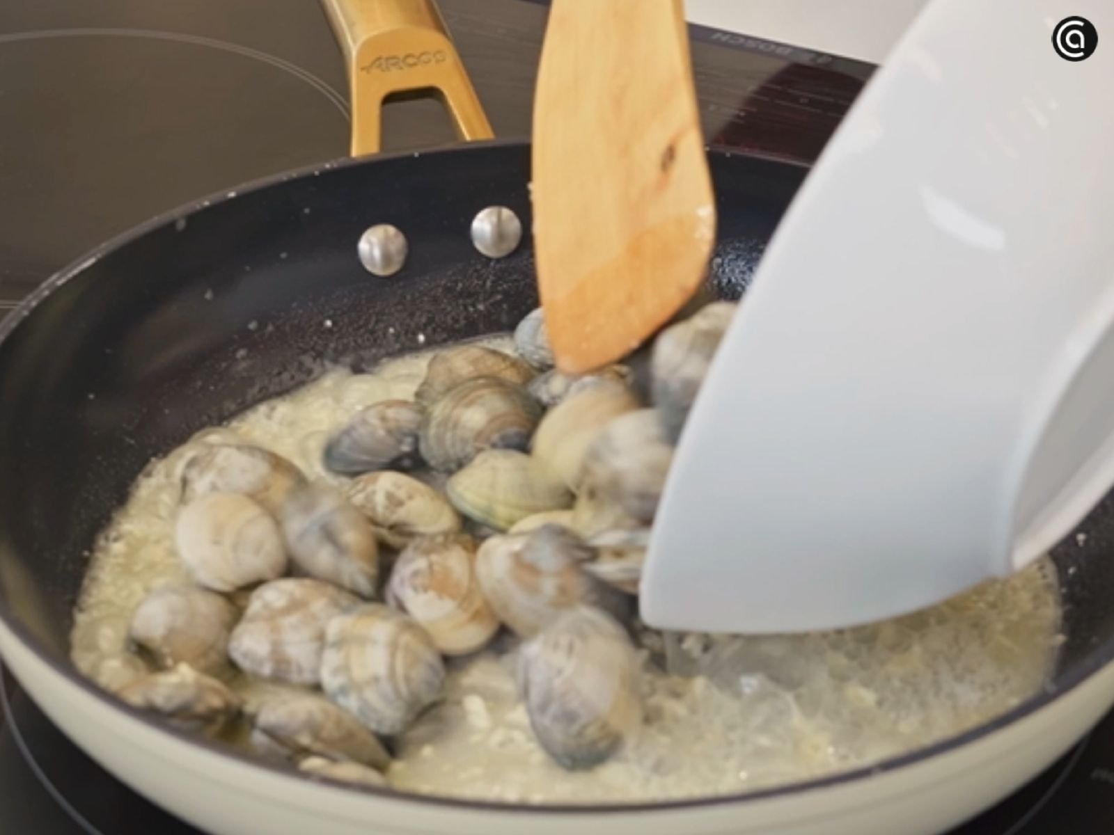 Las almejas limpias se añaden a la sartén para que comiencen a tomar temperatura.
