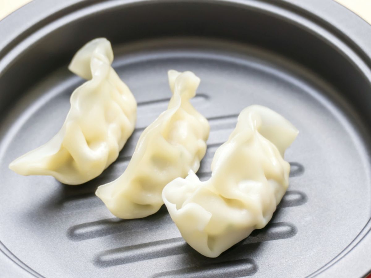 Coloca las gyozas directamente congeladas dentro de la cesta, sin amontonarlas