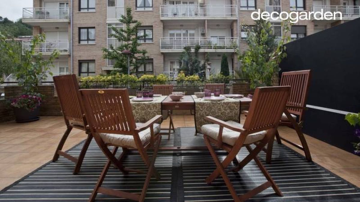Terraza decorada con sillas y mesa de madera.