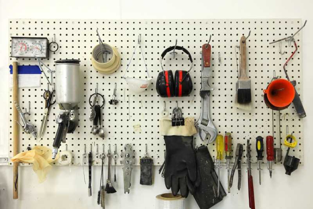 Panel perforado lleno de herramientas para organizar el garaje.