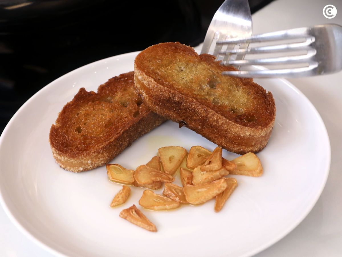 Pan y ajo dorados para enriquecer los garbanzos con langostinos