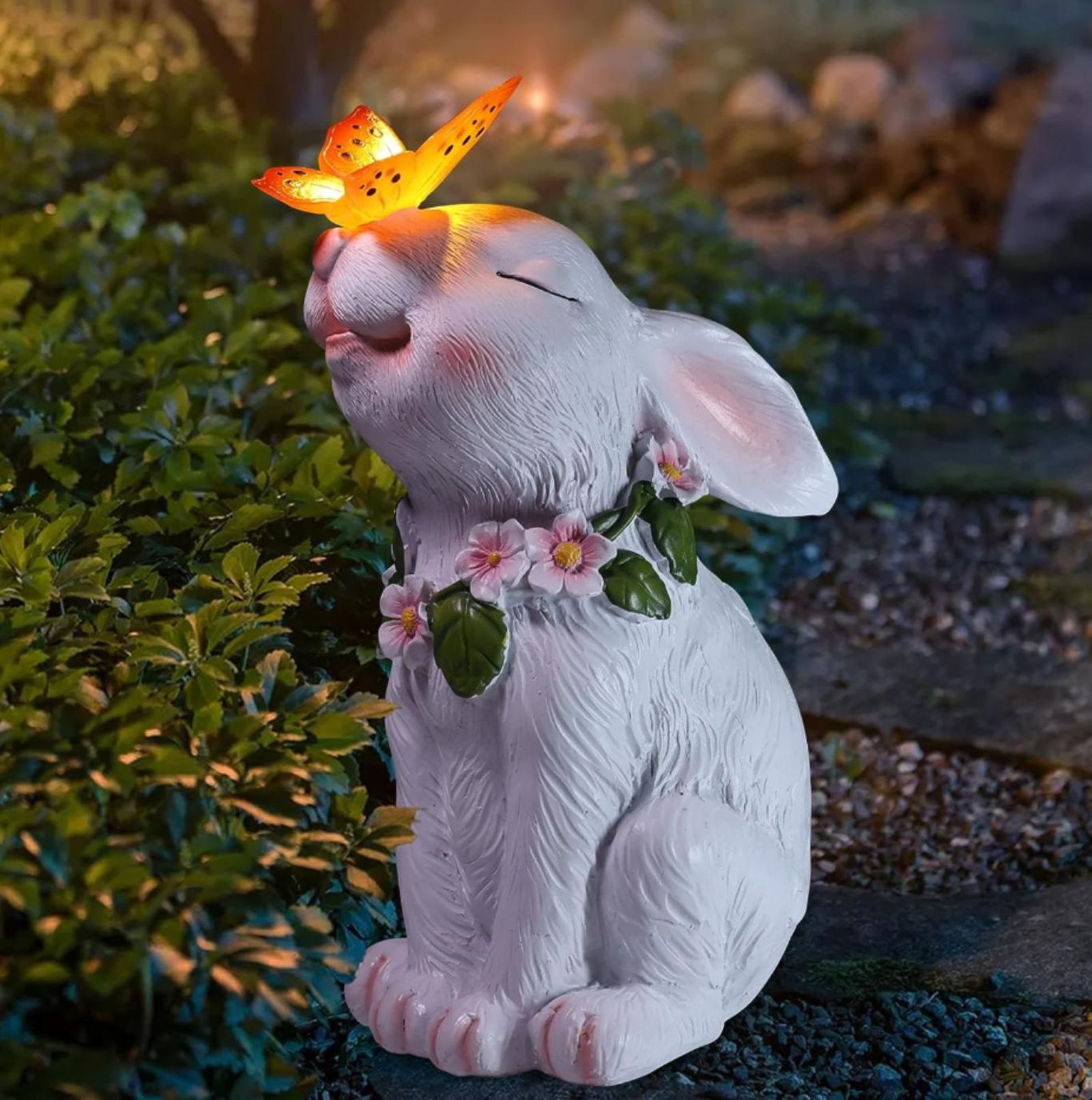 Figura de conejito de jardín con mariposa de luz solar. Figura de conejito de jardín con mariposa de luz solar.