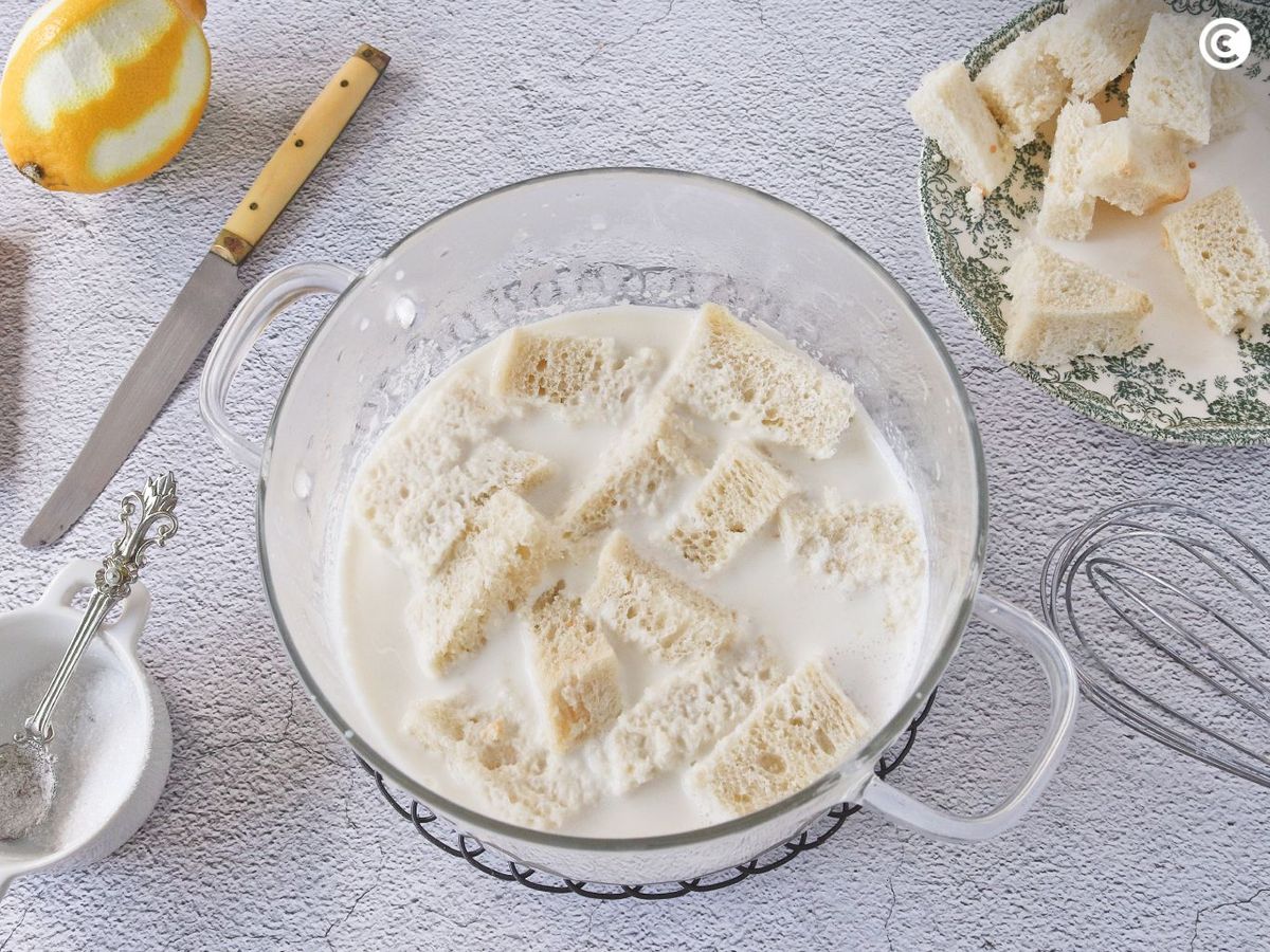 Empapar el pan en la leche para hacer la sopa de almendras