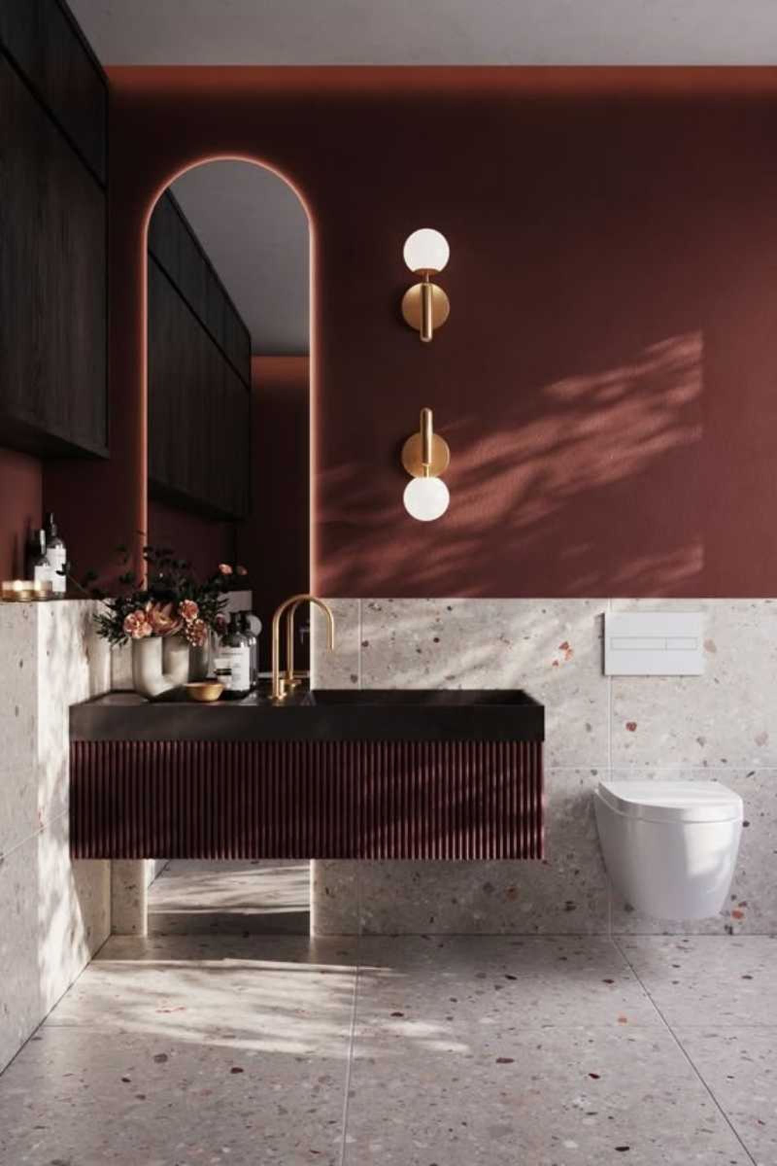 Baño con pared granate y suelo de terrazo.