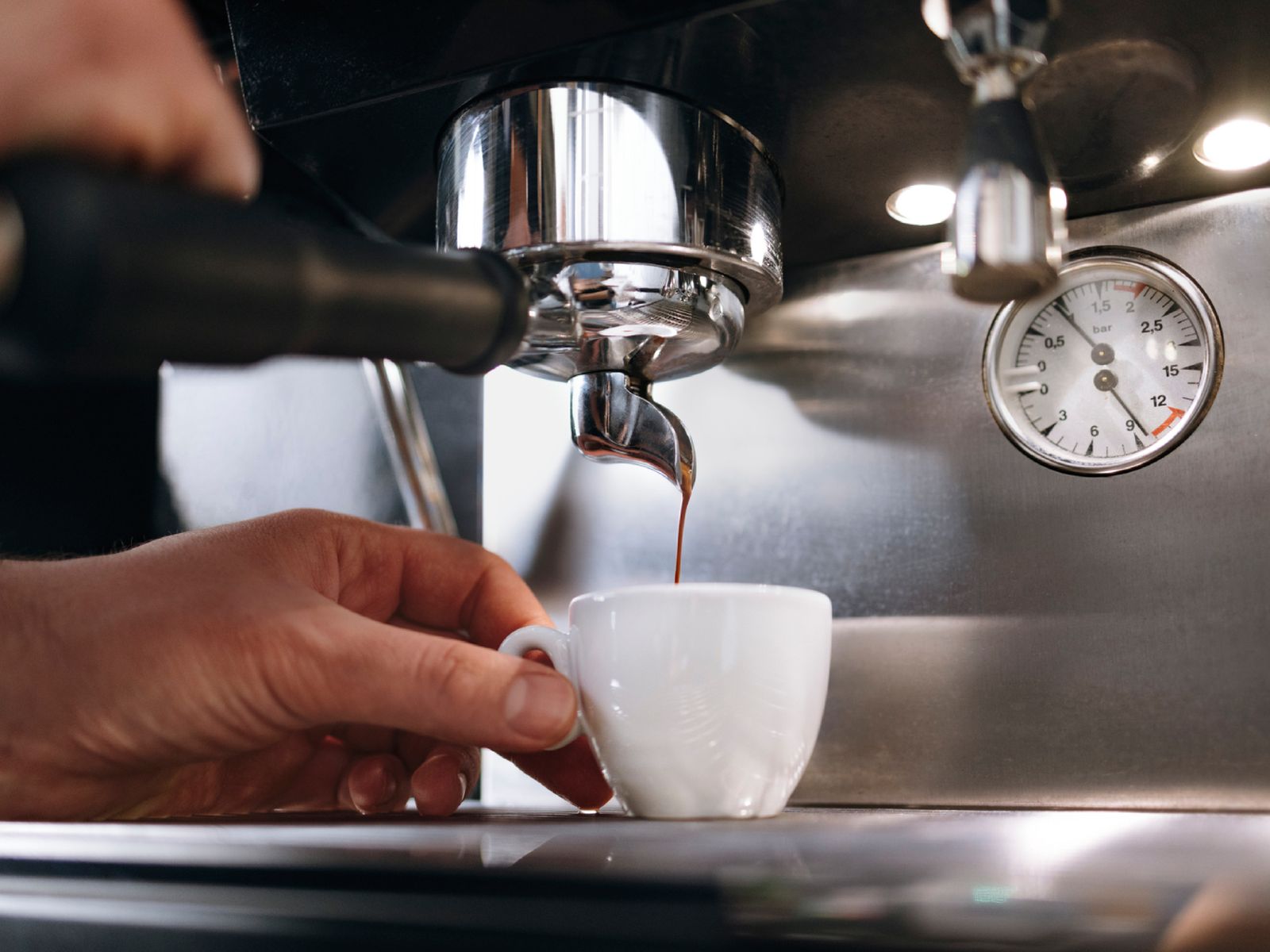 Una extracción perfecta: el espresso fluye en una hebra fina con la presión justa, alrededor de 9 bares.