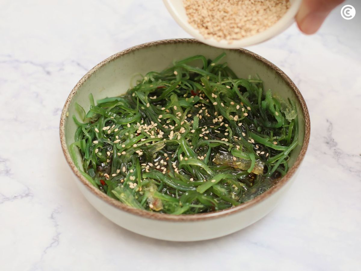 Espolvorear la ensalada de wakame con semillas de sésamo