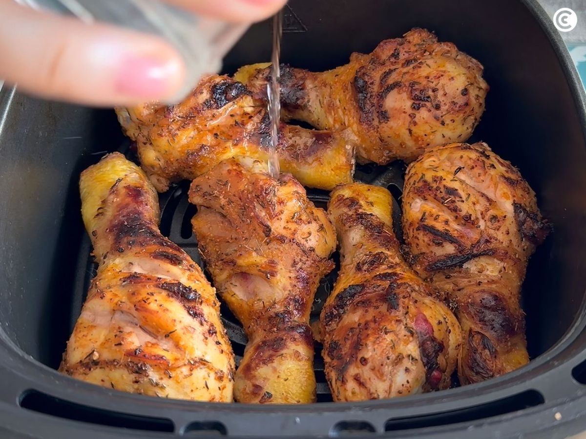 Añadir agua a los muslos de pollo en la freidora de aire