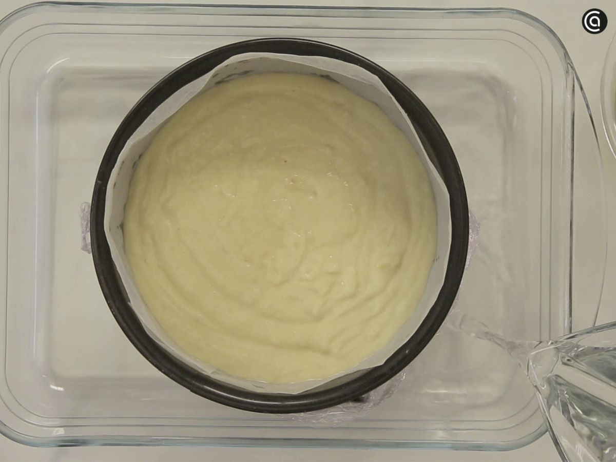 Vierte agua sobre la bandeja del horno para horenar al baño maría