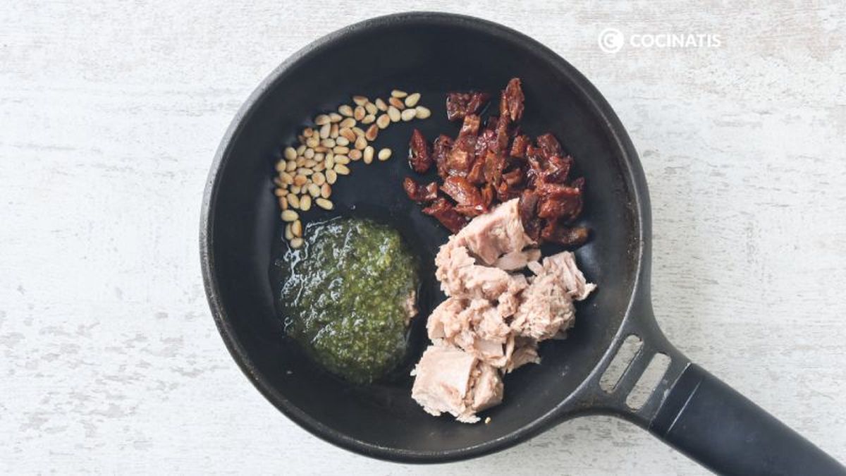 Mezclamos los piñones con el pesto, el atún y los tomates en aceite