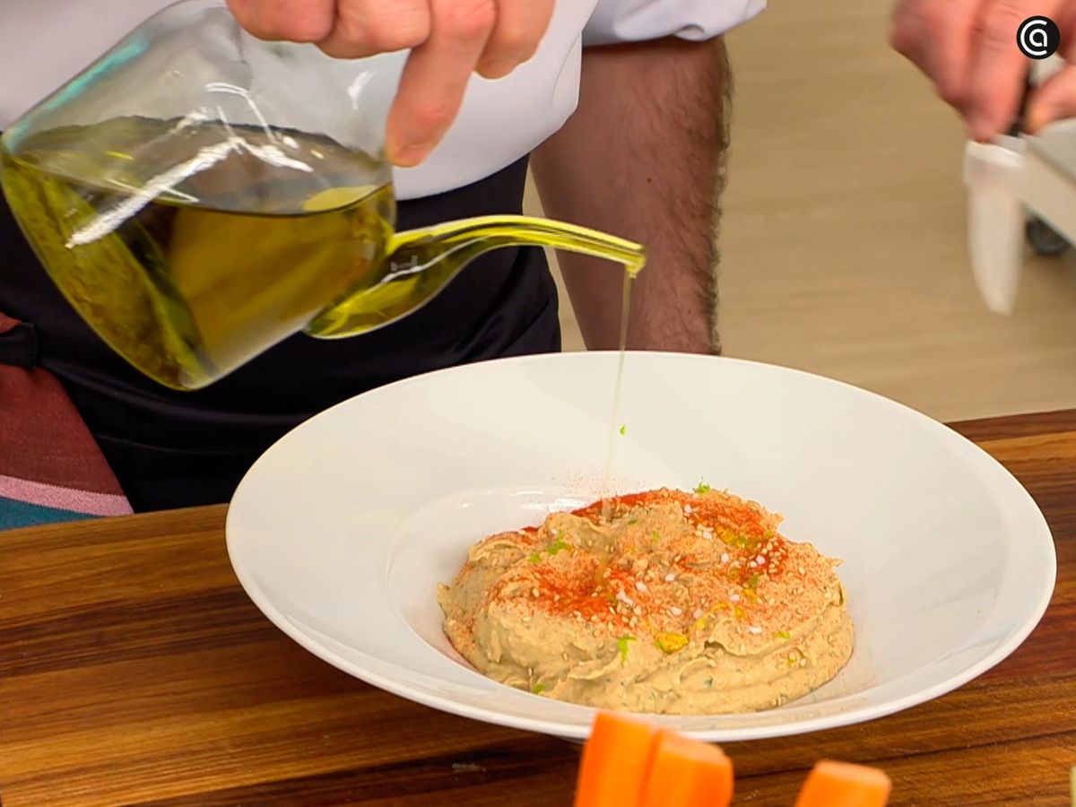 Espolvorea semillas de sésamo y un chorrito de aceite sobre el hummus de lentejas