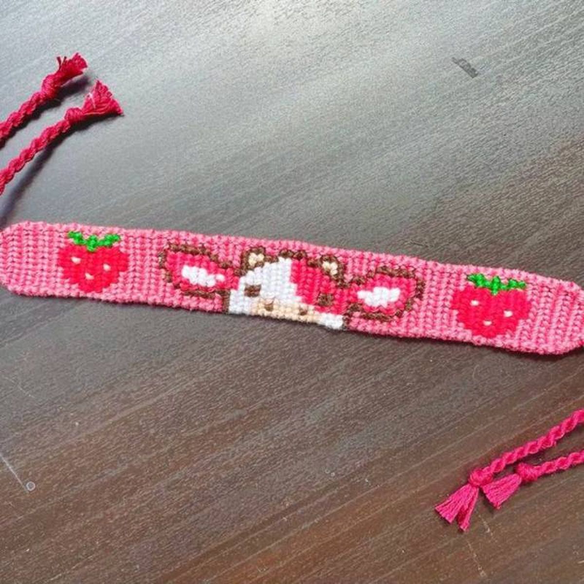 Pulsera de hilo de vaquita y fresas.