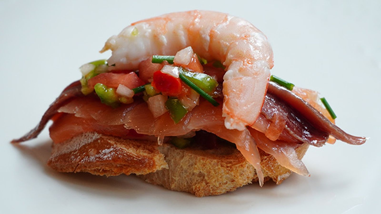 Tosta de anchoas con salmón ahumado y langostino Tosta de anchoas con salmón ahumado y langostino