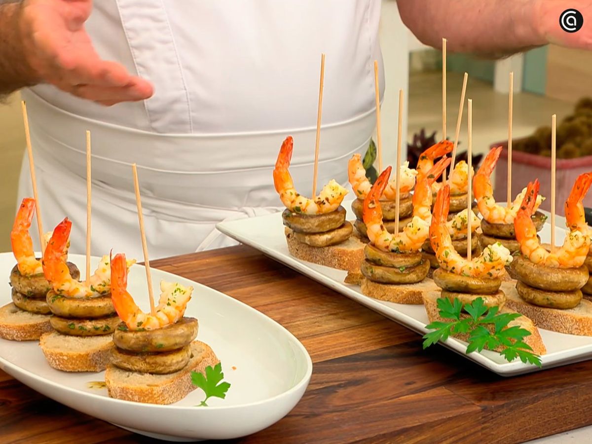 Coloca dos champiñones y un langostino sobre el pan y sujétalos con un palillo