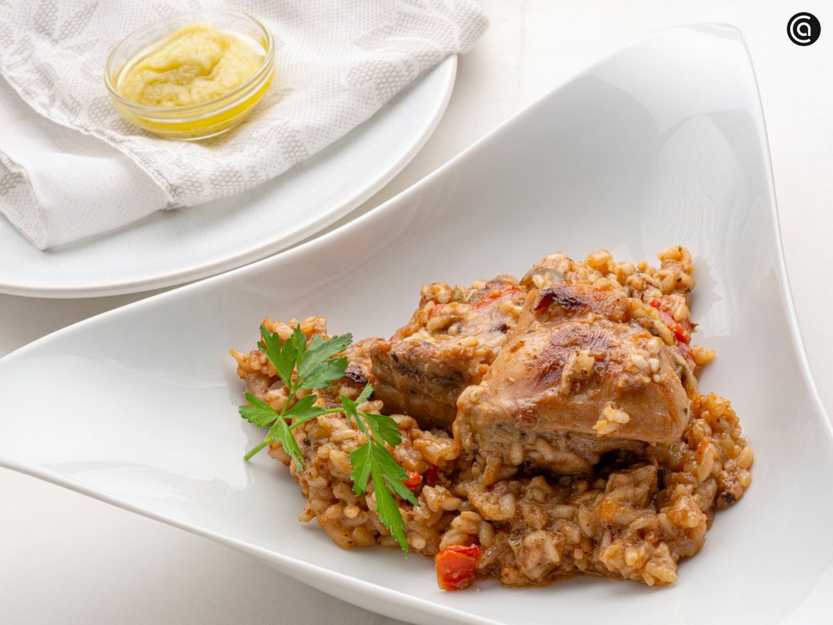 Sirve el arroz con carne de conejo acompañado de alioli