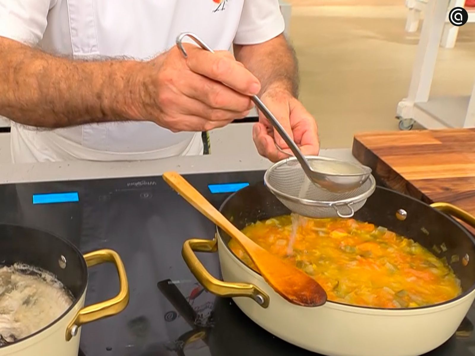 Añade el vino y el caldo de pescado a la cazuela