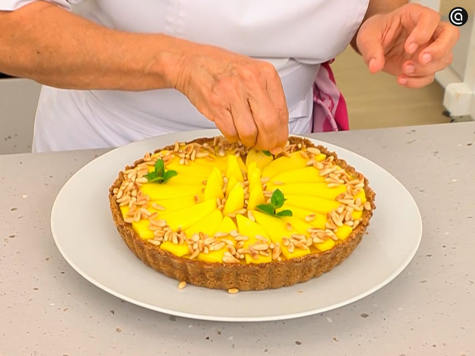 Coloca rodajas de mango, piñones tostados y menta para decorar