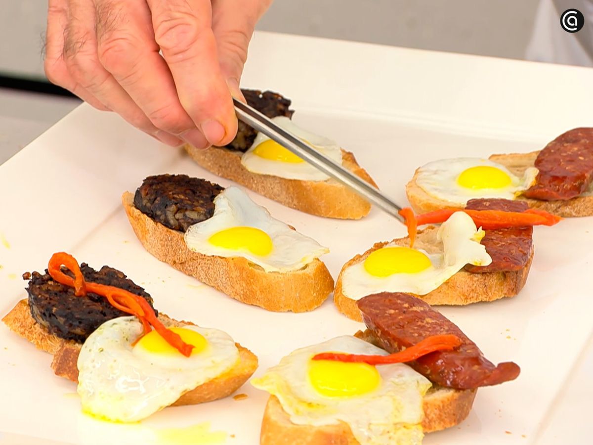Coloca el chorizo, la morcilla, el huevo frito y la alegría riojana sobre las rebanadas de pan