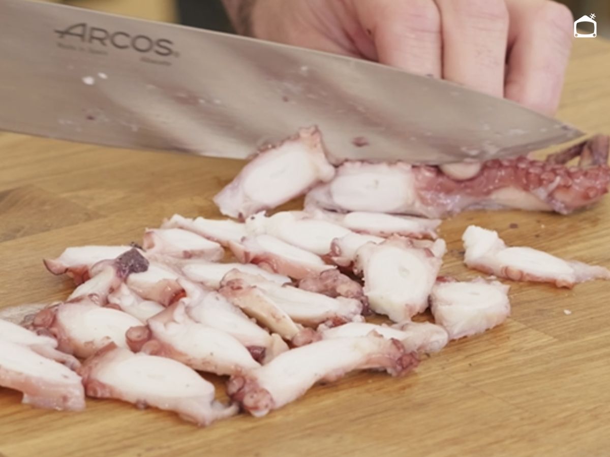 Cortamos las patas de pulpo en láminas finas para cubrir la mezcla con los encurtidos.