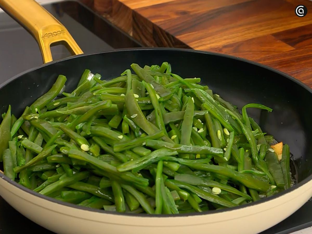 Sofríe ajo en láminas y mezcla con las judías verde