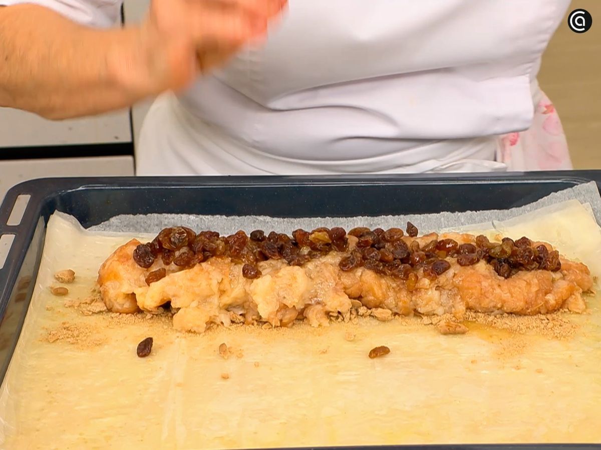 Reparte las galletas troceadas y cubre con la pera rallada y las pasas hidratadas