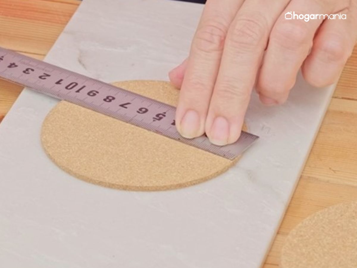 Se toma la medida del disco de corcho con una regla para marcar el punto exacto por donde se dividirá la pieza.
