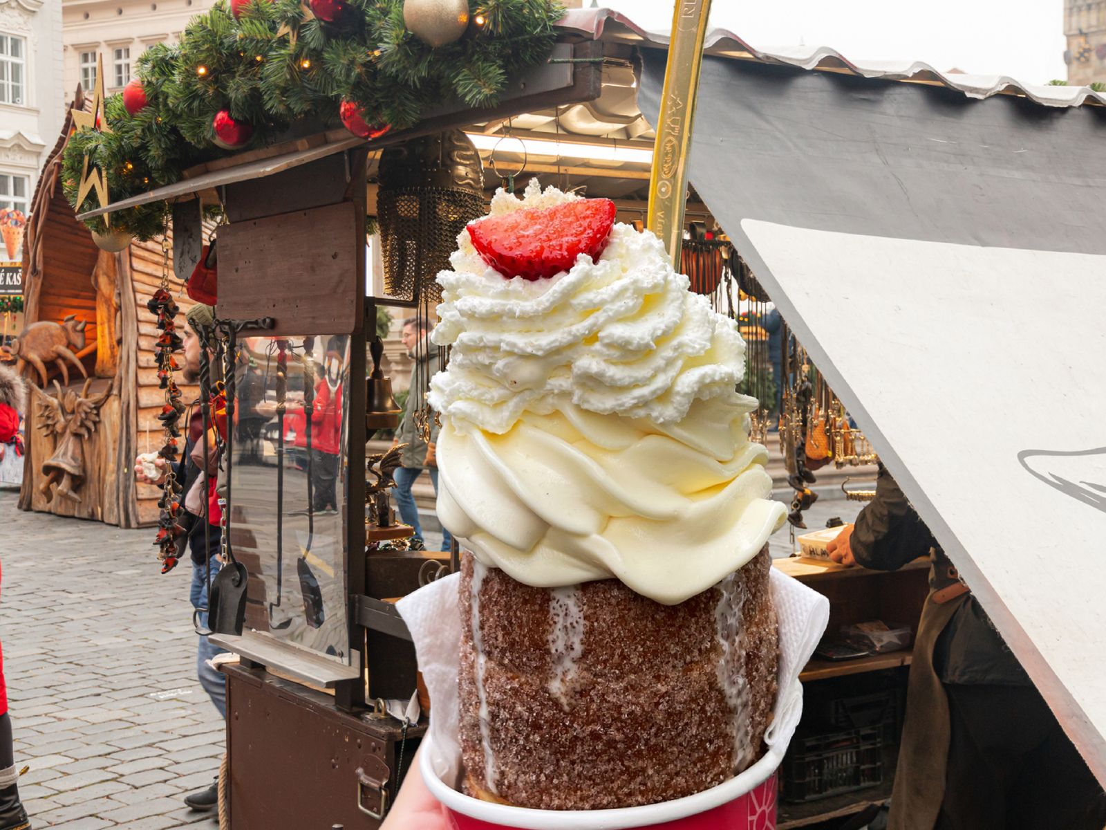 El famoso Trdelník de los mercadillos de Praga, una masa dulce asada sobre brasas y cubierta de azúcar y canela, servida con nata o helado.