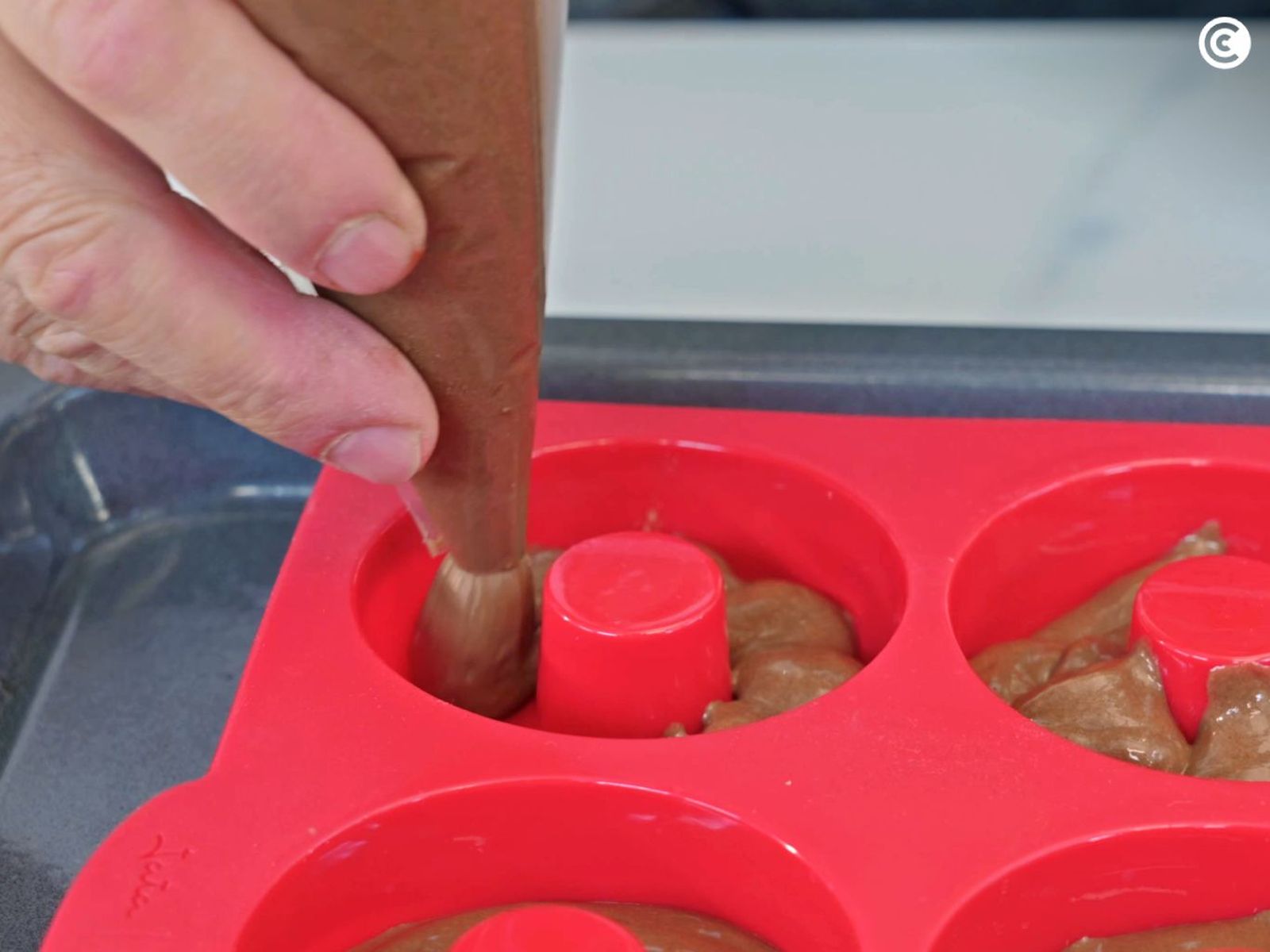 Rellenar los moldes de donuts con la masa Rellenar los moldes de donuts con la masa
