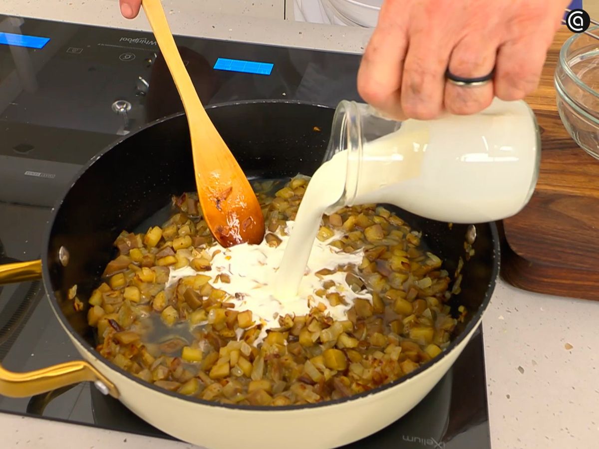 Vierte el jugo de los berberechos y la nata sobre las berenjenas y mezcla