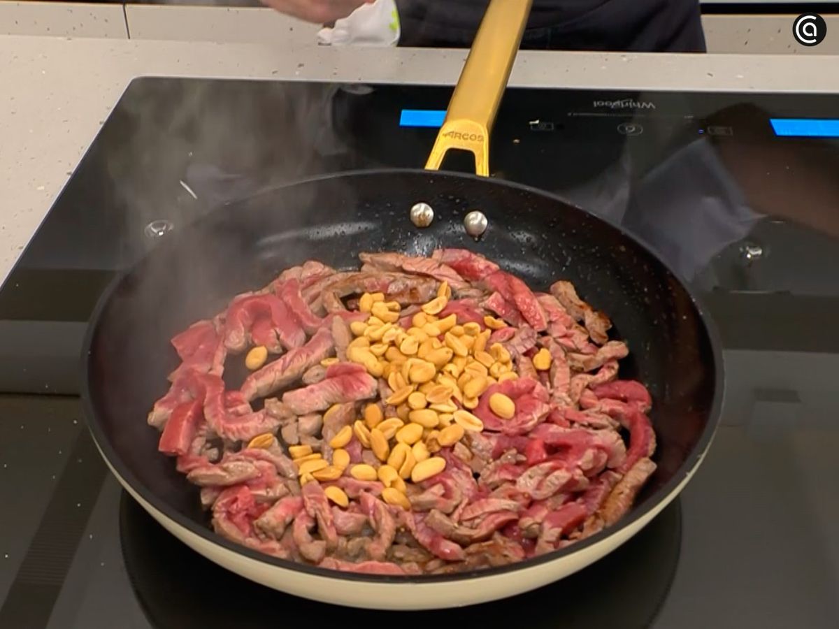 Saltea la ternera en tiras y mezcla con los cacahuetes