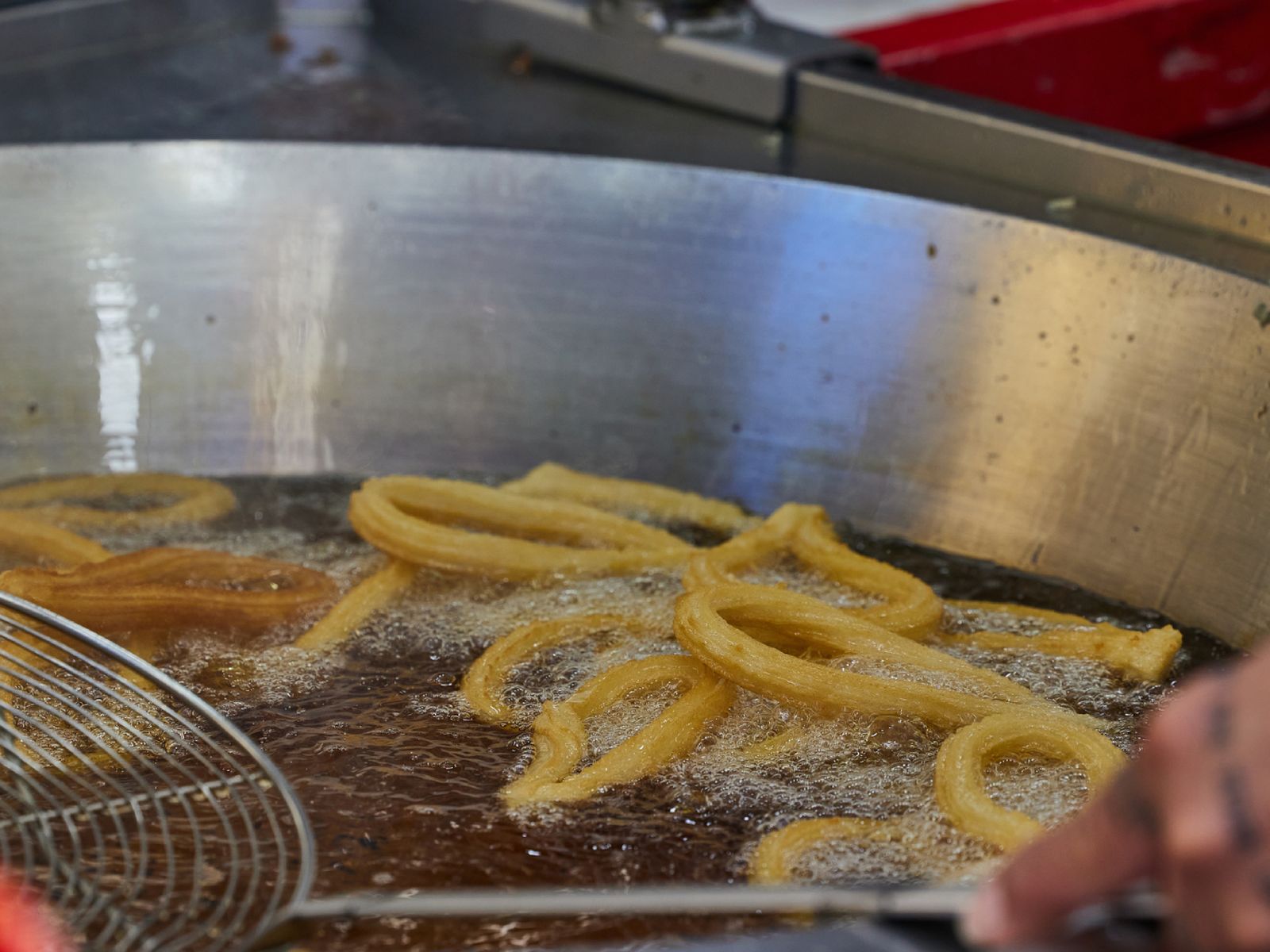 El momento clave: la masa burbujeando en aceite limpio y a temperatura justa, donde nace el buen churro. El momento clave: la masa burbujeando en aceite limpio y a temperatura justa, donde nace el buen churro.
