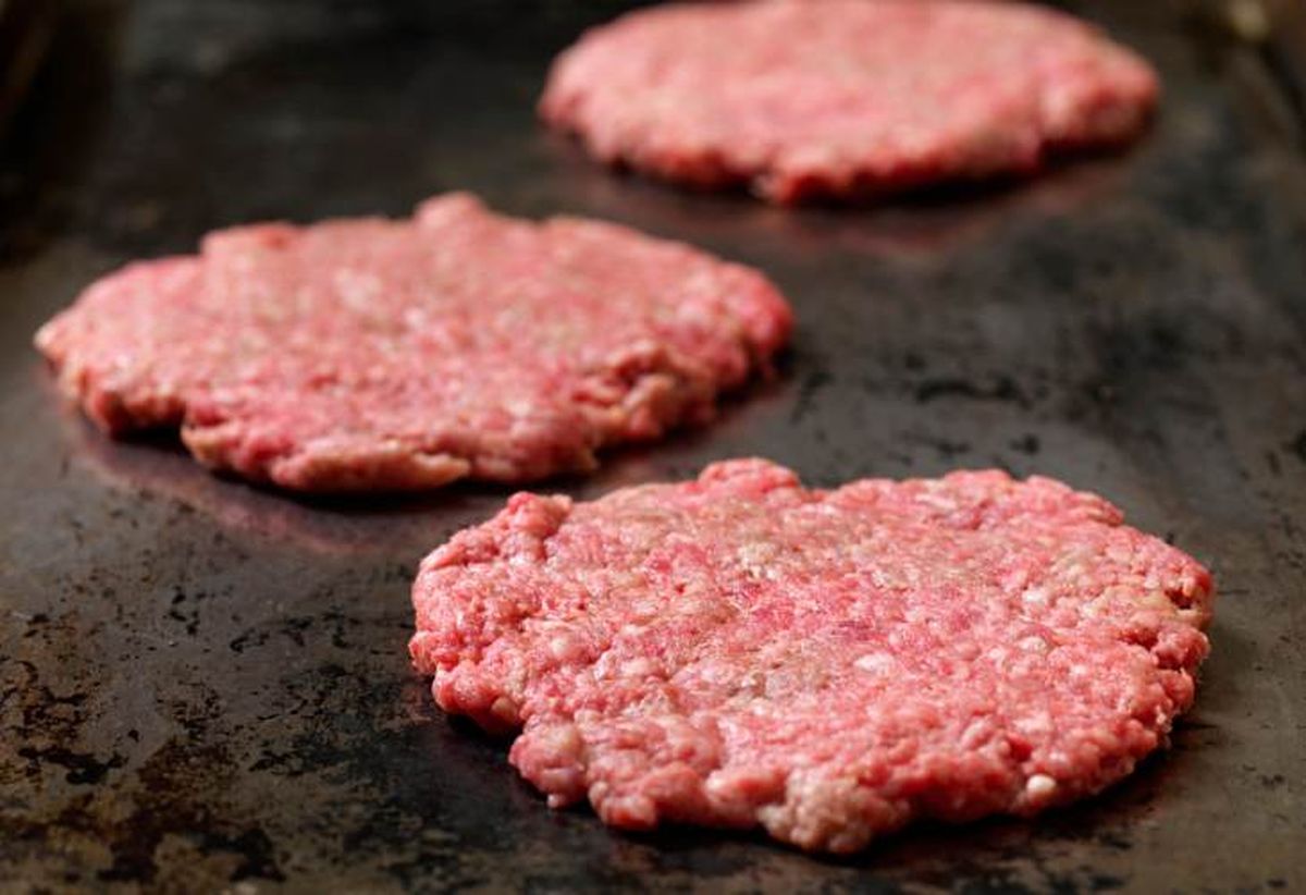 La técnica de cocción para hacer una smash burger implica aplastar la carne