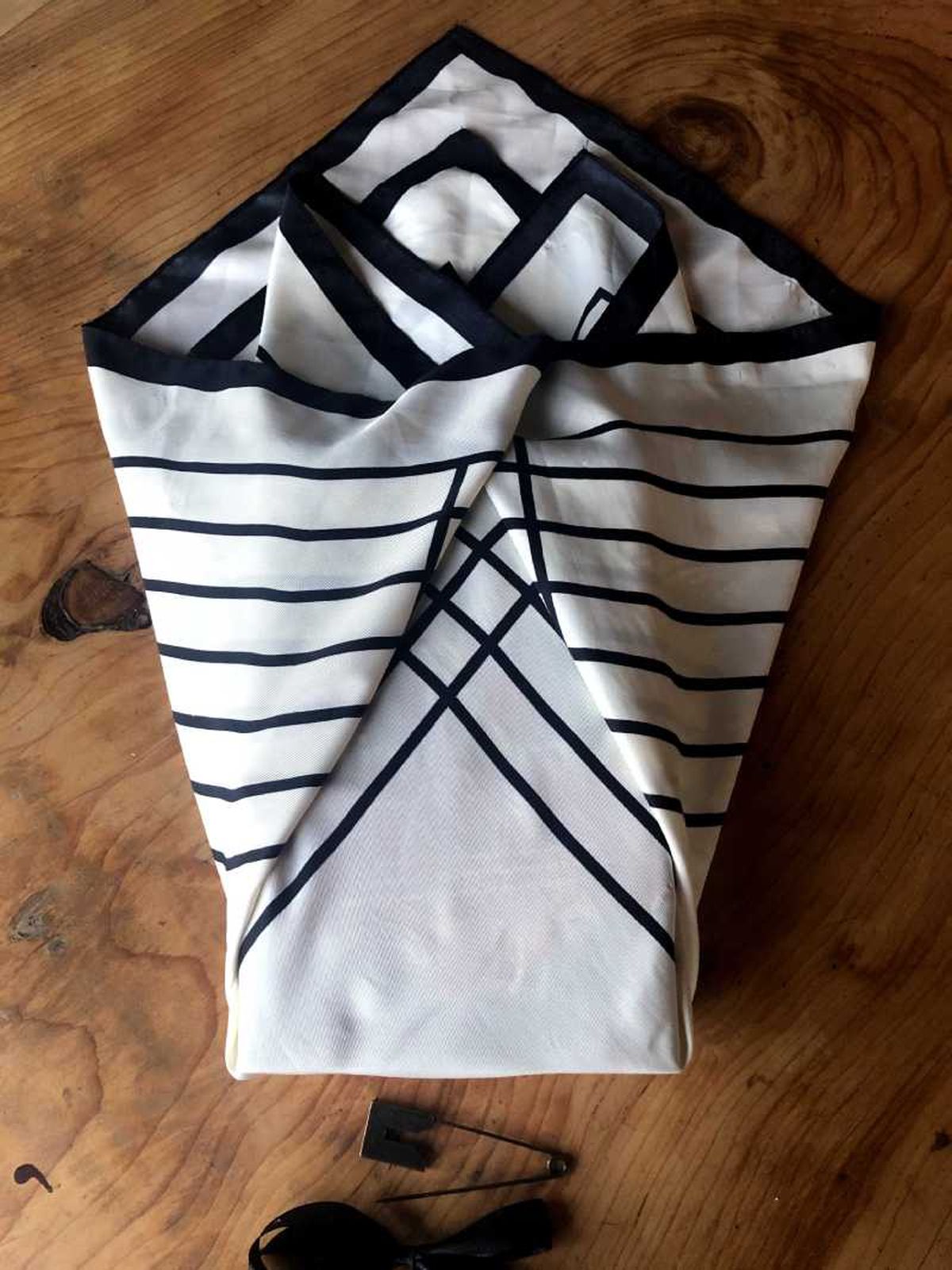 Paso tres para envolver un libro en tela furoshiki.