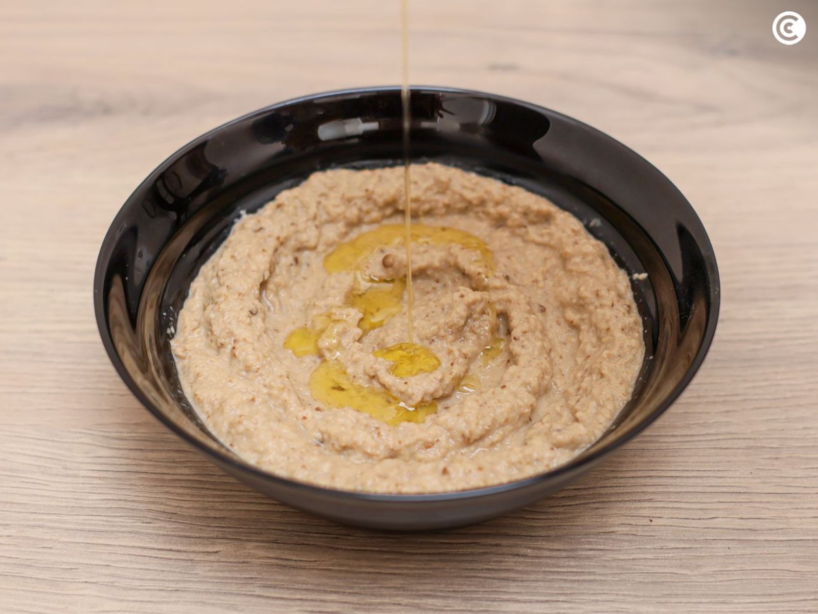 Agregar aceite sobre el hummus de berenjena