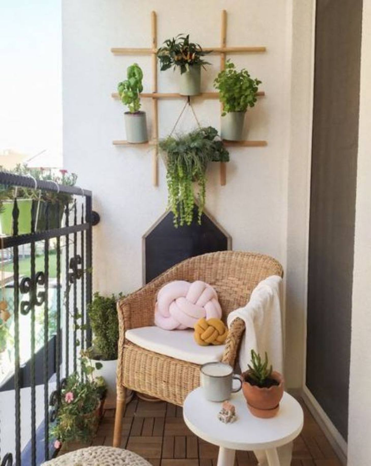 Balcón pequeño decorado con una mesita y plantas.