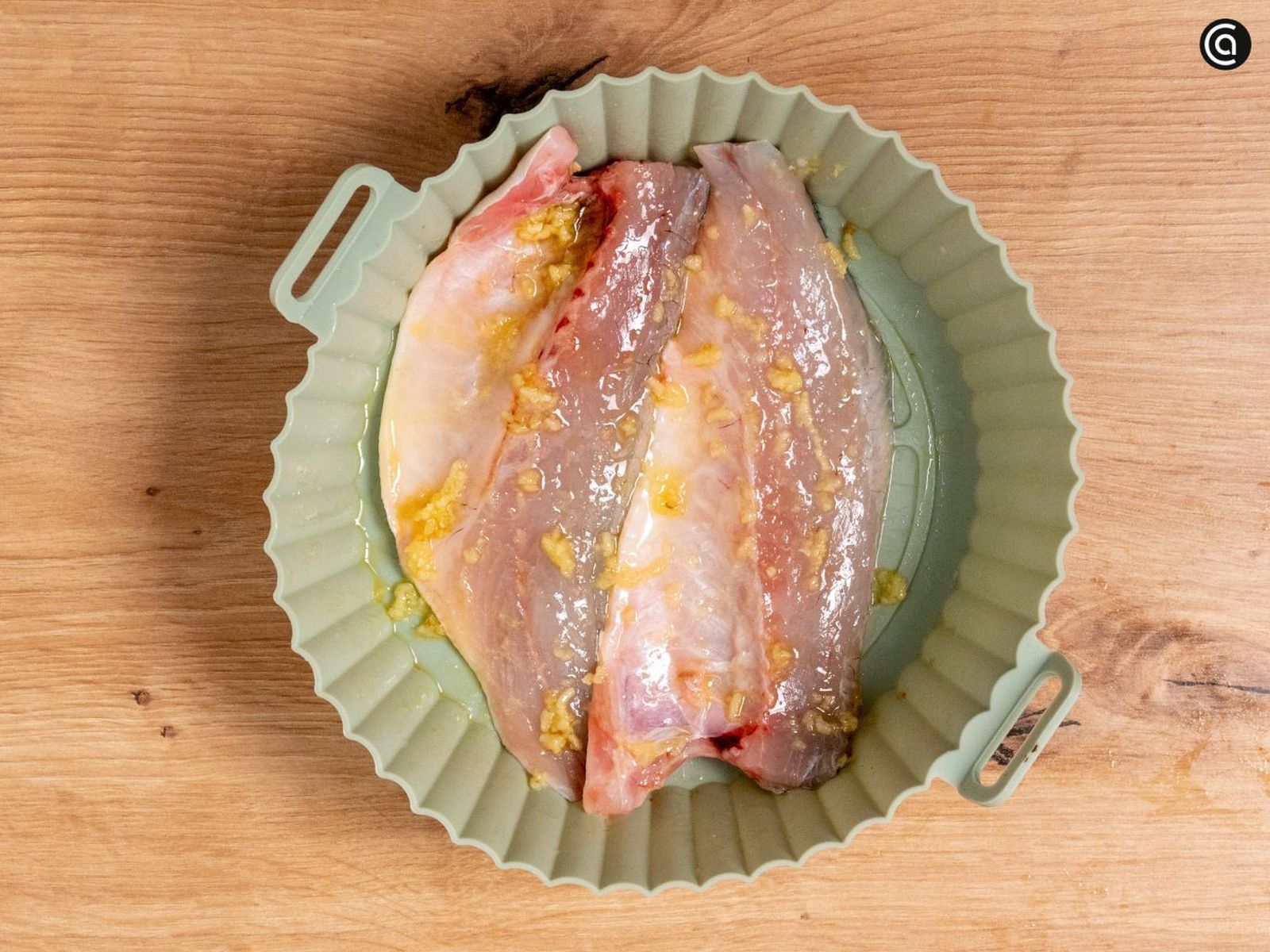 Condimenta la lubina con ajo, sal y aceite de oliva antes de cocinarla