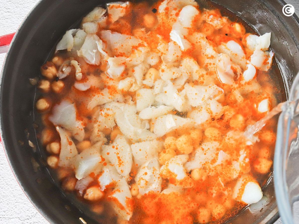 Agregar agua y bacalao a los garbanzos