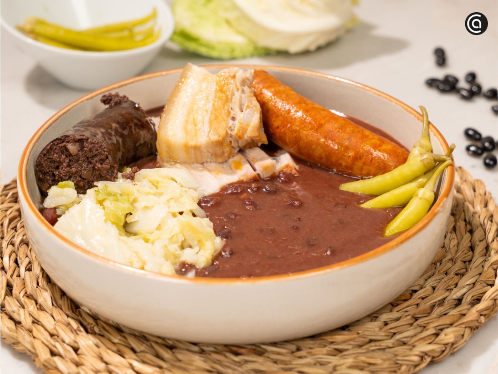 El resultado final: alubias melosas, berza tierna y sacramentos jugosos, servidos con las imprescindibles piparras de Ibarra. Un plato de cuchara completo, con las alubias cremosas y sus sacramentos cocinados por separado para mantener todo el sabor.