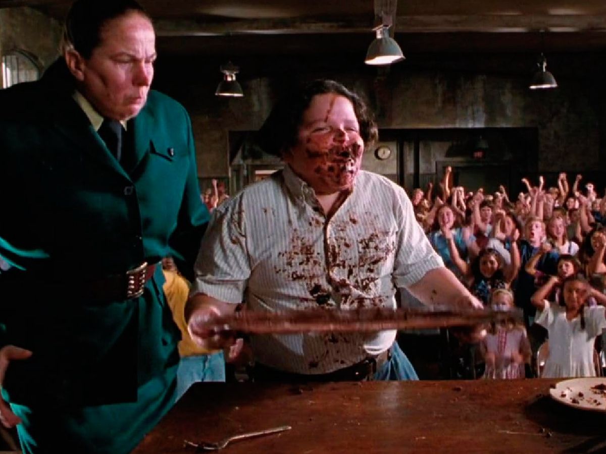 En Matilda, una de las escenas más recordadas muestra a un alumno obligado a comer un enorme pastel de chocolate