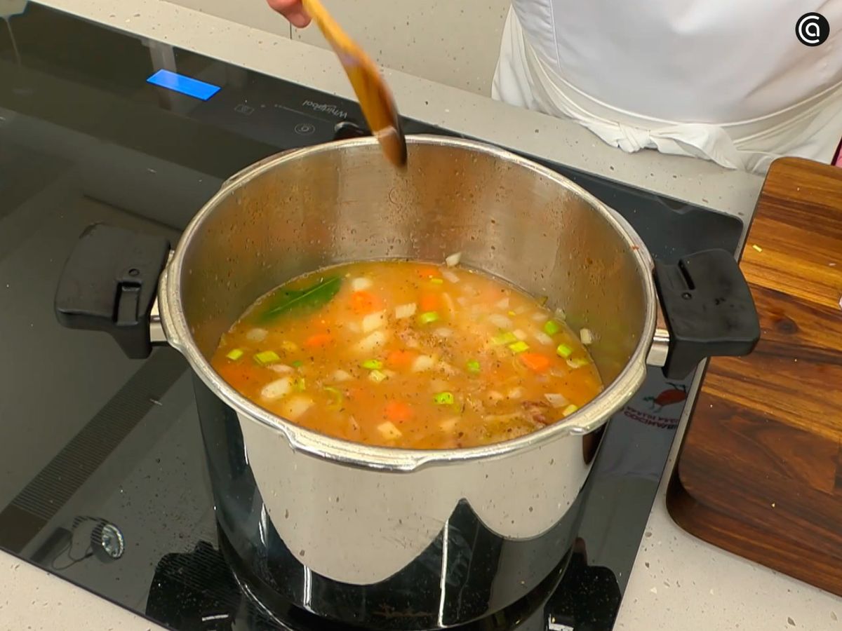 Guisa en la olla rápida el conejo con las alubias y las verduras