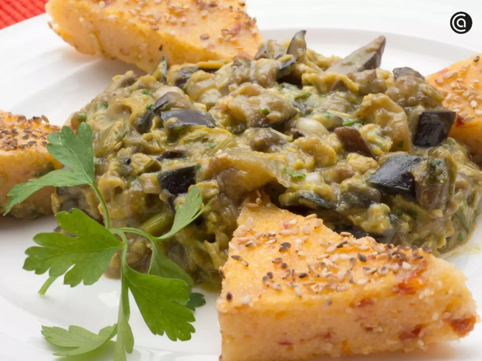 Polenta firme cortada en porciones, servida con un salteado jugoso de berenjenas y setas. Polenta firme cortada en porciones, servida con un salteado jugoso de berenjenas y setas.